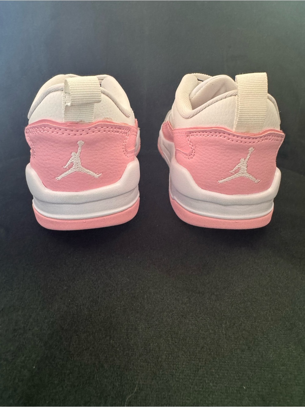New without box.  Sold by Nike. Pink and White Low-Top Sneakers with Jordan logo